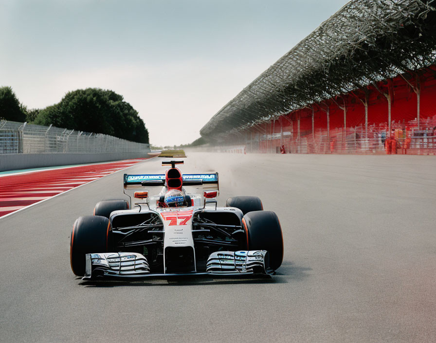 Number 7 racing car speeds on track with driver and empty grandstands