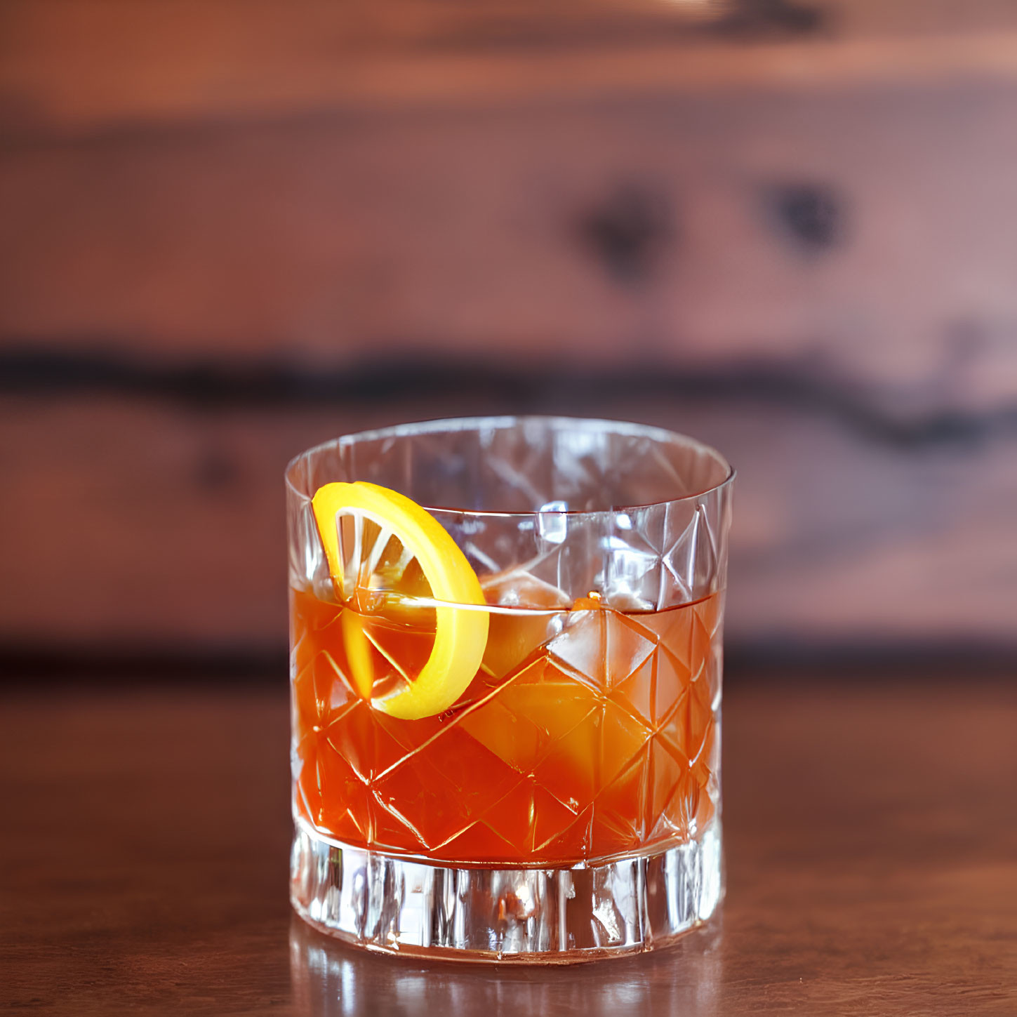 Amber Cocktail with Orange Twist on Wooden Surface