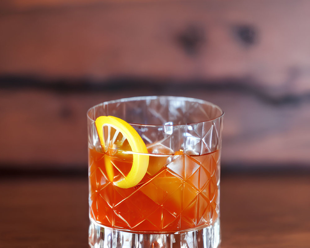 Amber Cocktail with Orange Twist on Wooden Surface