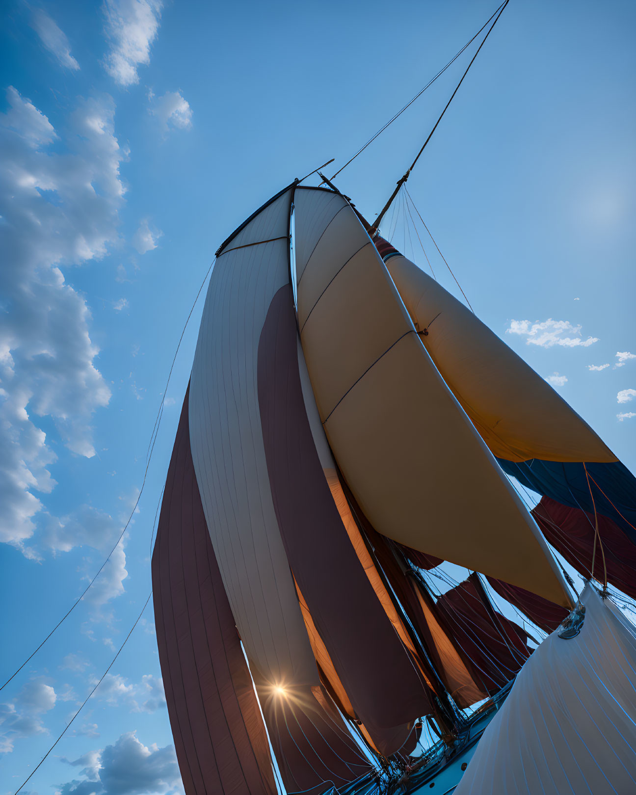 Sailboat with unfurled sails under sunny sky