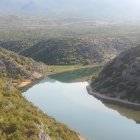 Scenic landscape featuring multi-level dam in canyon with clear sky