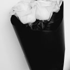 Grayscale bouquet with three white roses in dark paper