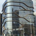 Modern building with golden reflective surfaces and spherical structures against blue sky