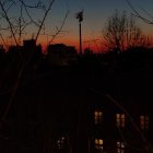 City skyline silhouette with crescent moon in twilight sky.