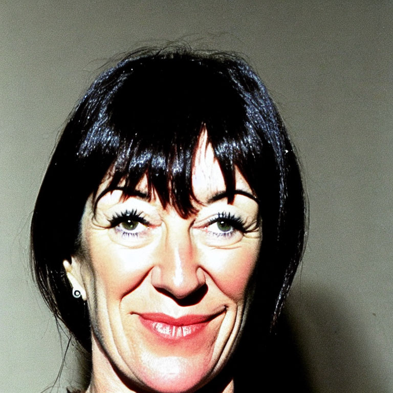 Smiling woman with black hair and bangs portrait.