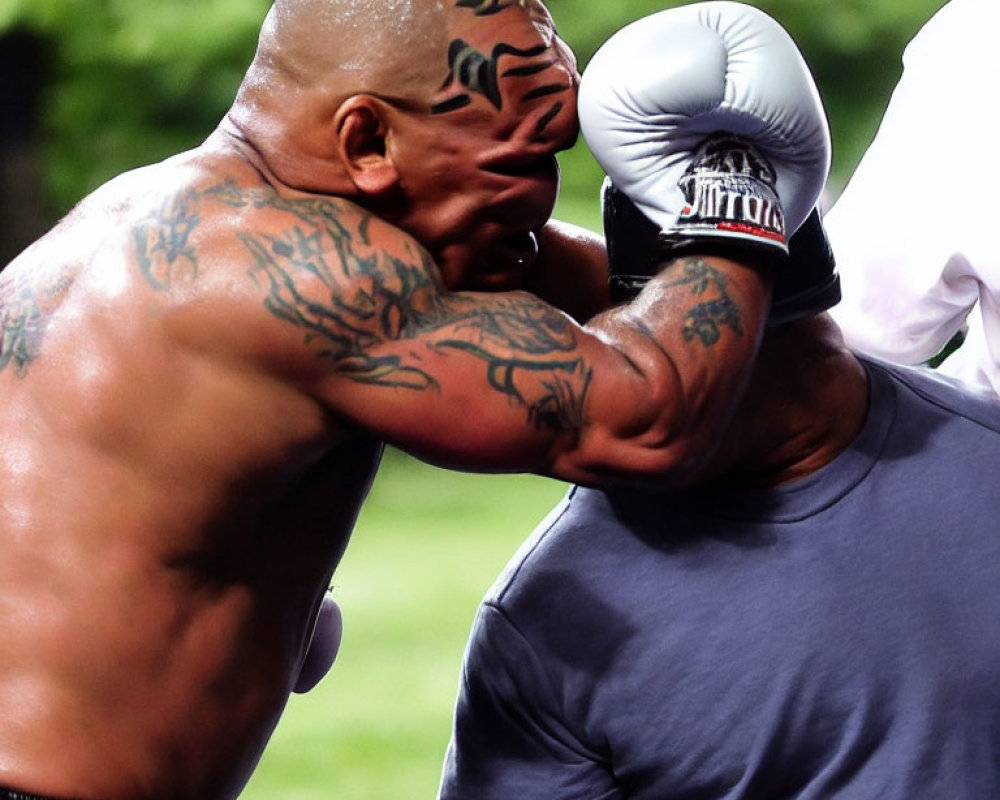 Muscular men boxing with head guard punch.