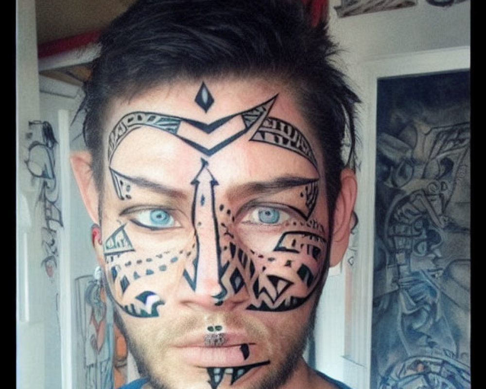 Person with tribal black face paint in front of art wall wearing blue shirt