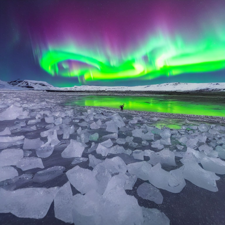 Person under vibrant aurora borealis in frozen landscape at night