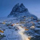 Scenic Arctic village with colorful houses under towering mountain at dusk