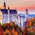 Enchanting castle with spires in autumn forest landscape