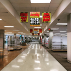 Deserted supermarket interior with dusty shelves and strip lighting