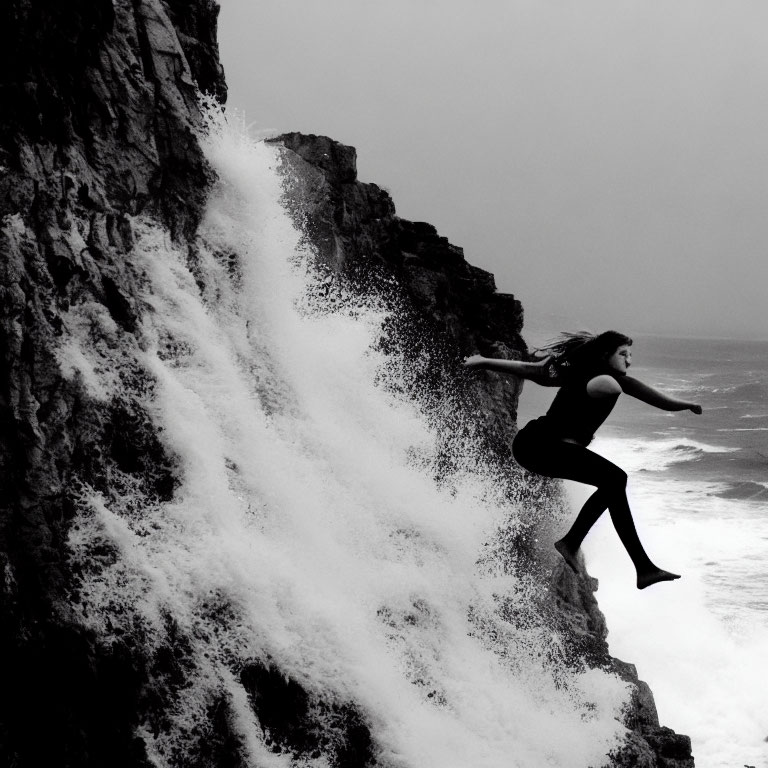 Person cliff jumping into sea with crashing waves - Dramatic black and white photo