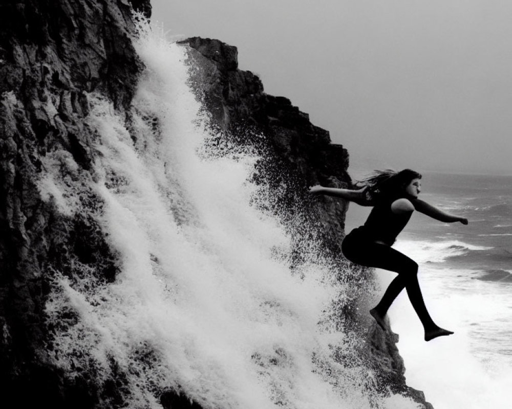 Person cliff jumping into sea with crashing waves - Dramatic black and white photo