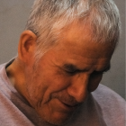 Elderly man smiling with white beard and snowflakes