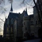 Mystical twilight scene of old Gothic town with warmly lit windows