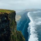 Surreal landscape featuring floating orbs, sailing ship, sea divide, cliffs, and lush greenery