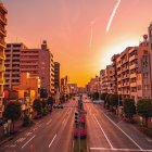 Golden sunset cityscape with illuminated buildings and cobbled street