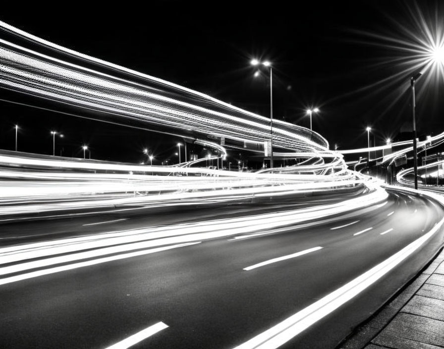 Monochrome long-exposure photo of light trails on highway