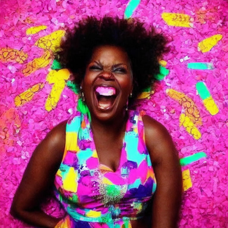 Smiling woman with curly hair in colorful top on vibrant pink background