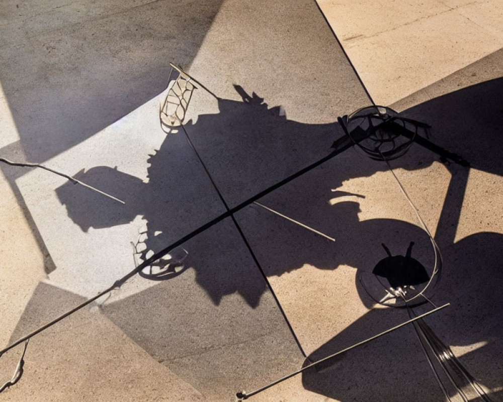 Abstract outdoor scene: table, chairs, long shadows, light & dark pattern