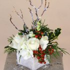 White Poinsettia, Pine Branches, and Red Berries in Snowy Vase