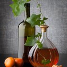 White Cosmos Flower in Vase with Golden Bottle and Seeds on Patterned Background