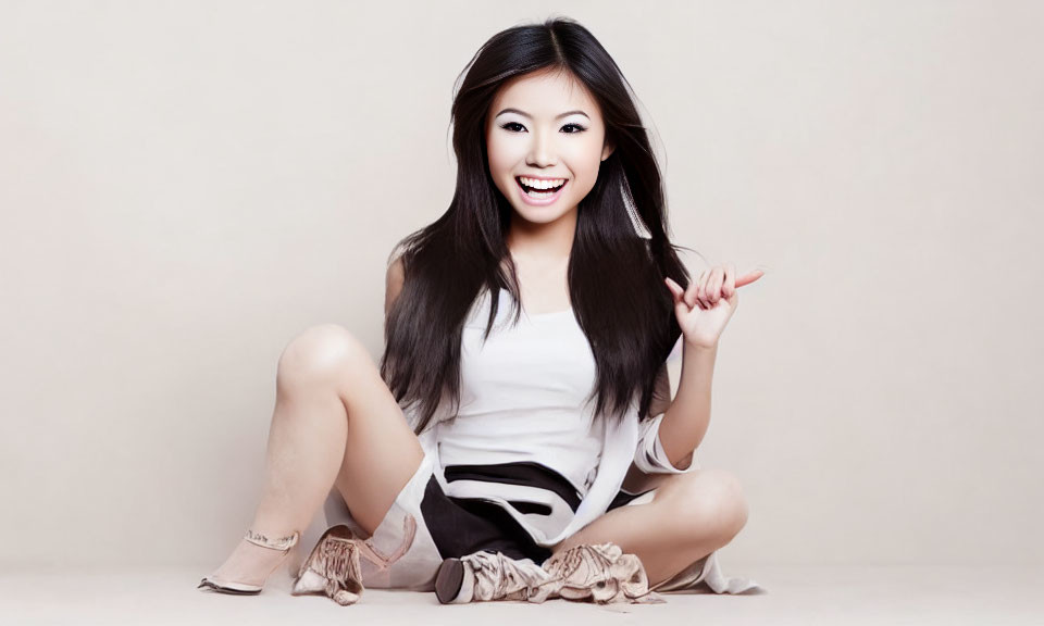 Dark-Haired Woman Sitting in White Top and Black Shorts