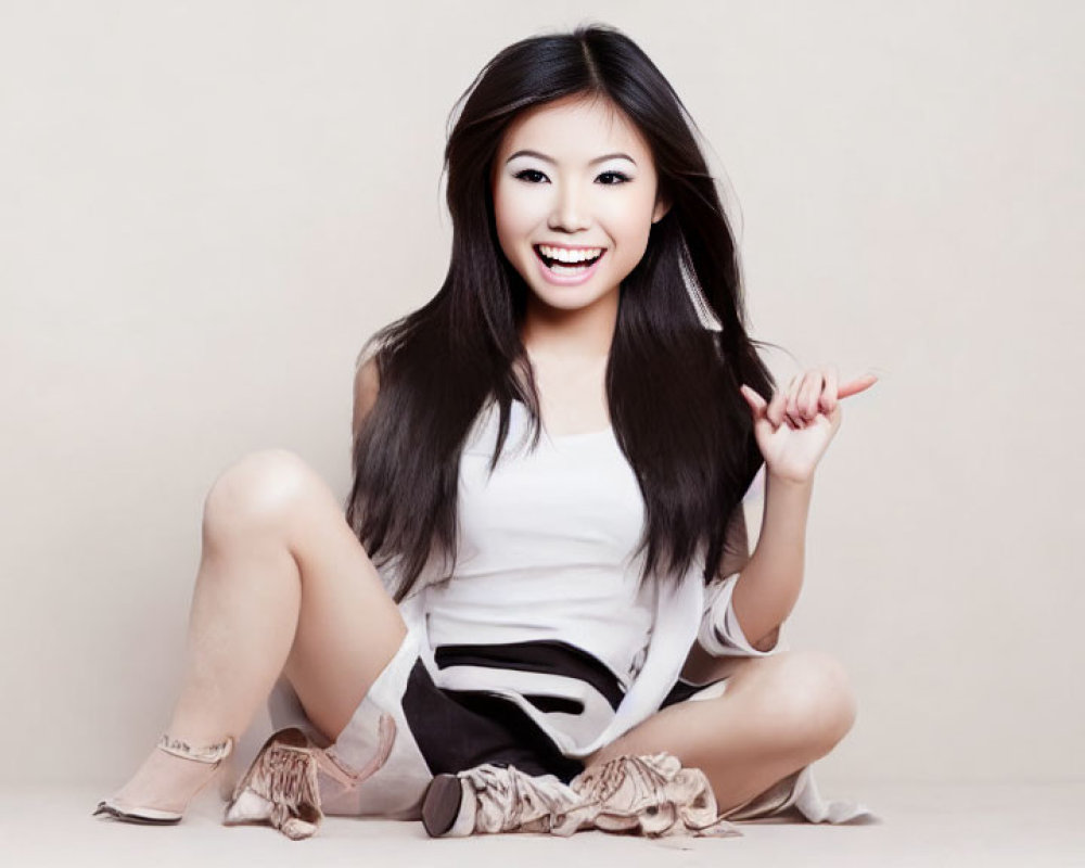 Dark-Haired Woman Sitting in White Top and Black Shorts