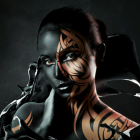 Woman with black and blue face and body paint against abstract background