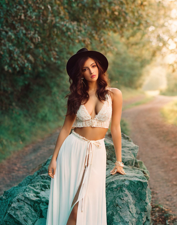 Stylish woman in hat on tree-lined path exudes elegant summer vibe