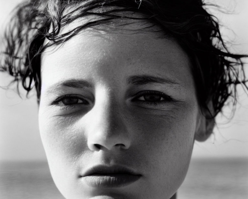 Monochrome portrait of young person with windblown hair