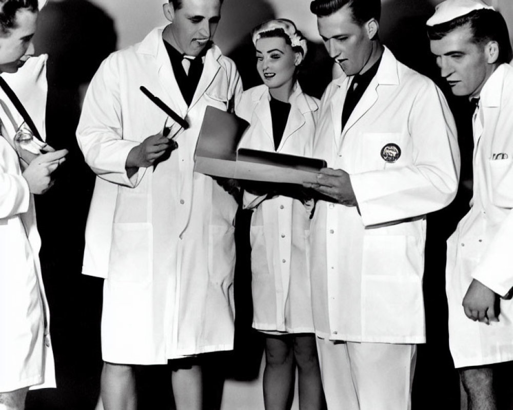 Group of five individuals in white lab coats discussing document closely