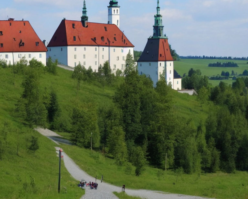 Cobblestone Path Through Green Landscape to White Building with Red Roof