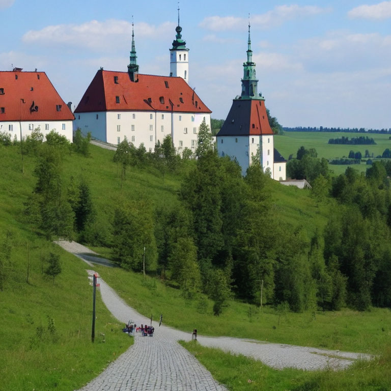 Cobblestone Path Through Green Landscape to White Building with Red Roof