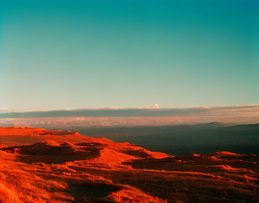 Tranquil golden hour landscape with orange-red hues over rolling hills