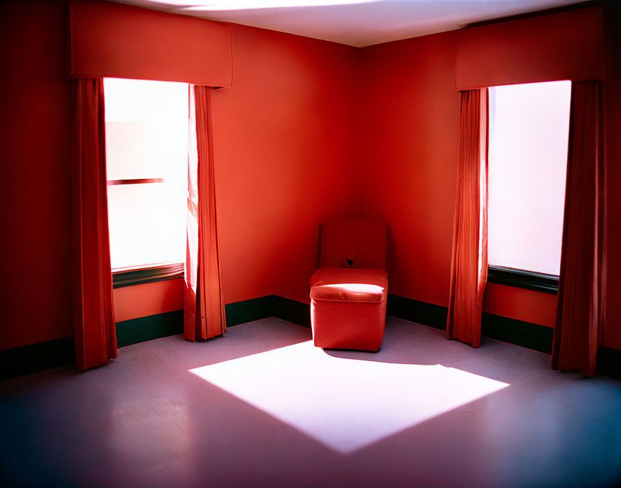 Red-Walled Room with Chair and Natural Light from Windows