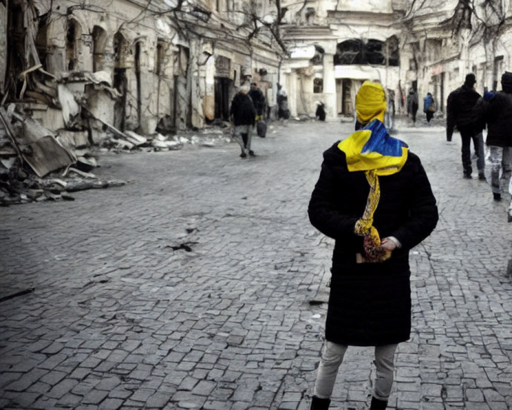 Person in Yellow and Blue Headscarf Amid War-Torn Street