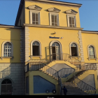 Yellow Colonial-Style Building with Weathered Walls and Arched Windows