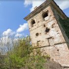 Majestic castle on cliff with waterfall, lush greenery