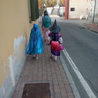 Warrior woman leads blue creature chased by serpent in fantasy alleyway