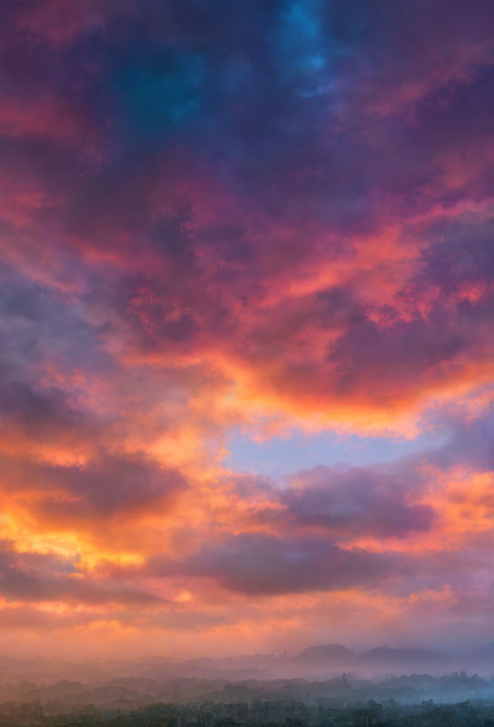 Vivid Pink, Orange, and Blue Sunset over Misty Forest Landscape