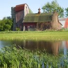 Tranquil barn by reflective pond with ducks and swan in lush landscape