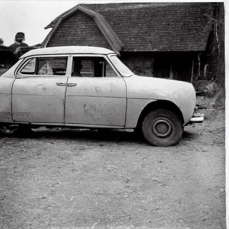 Monochrome image of vintage car, building, and person