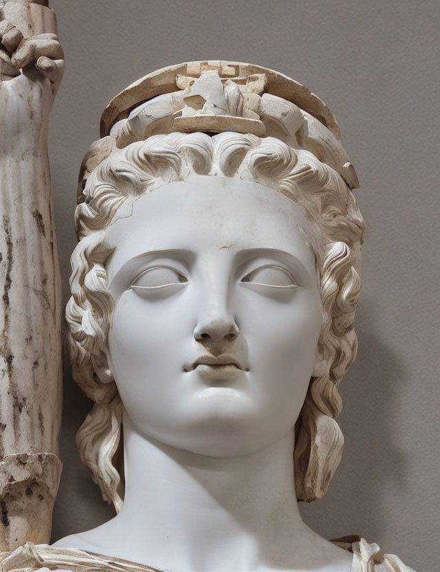 Classical marble sculpture of a woman's head with intricate carved hair and diadem