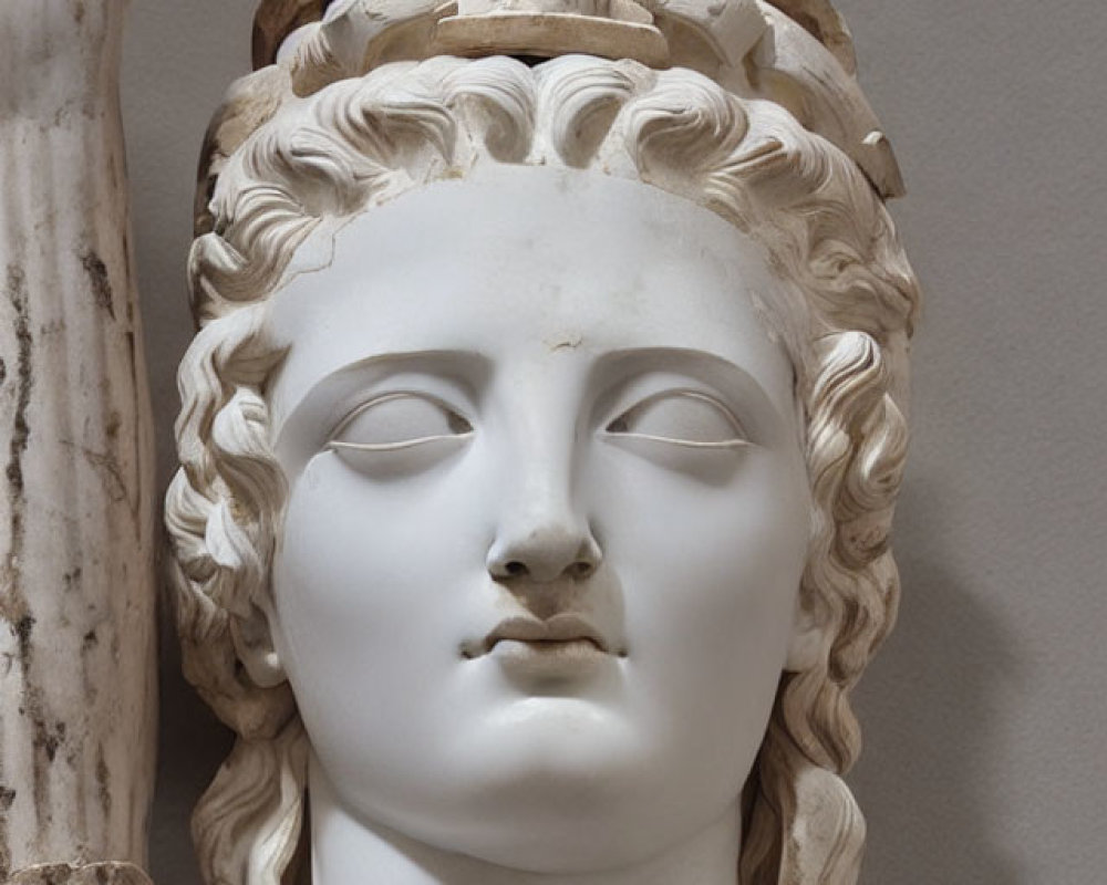 Classical marble sculpture of a woman's head with intricate carved hair and diadem