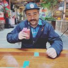 Man in Blue Cap Balancing Potatoes with Credit Card on Table