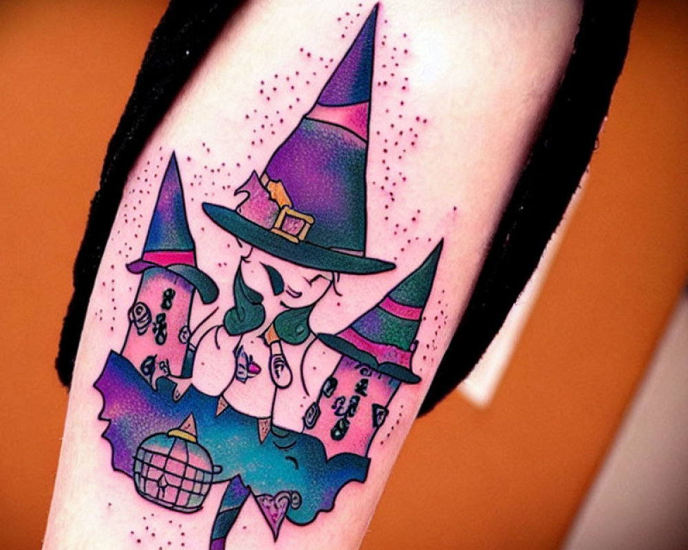 Vibrant witch-themed arm tattoo with purple hat, bats, and potion