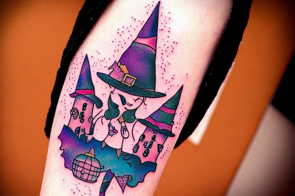 Vibrant witch-themed arm tattoo with purple hat, bats, and potion