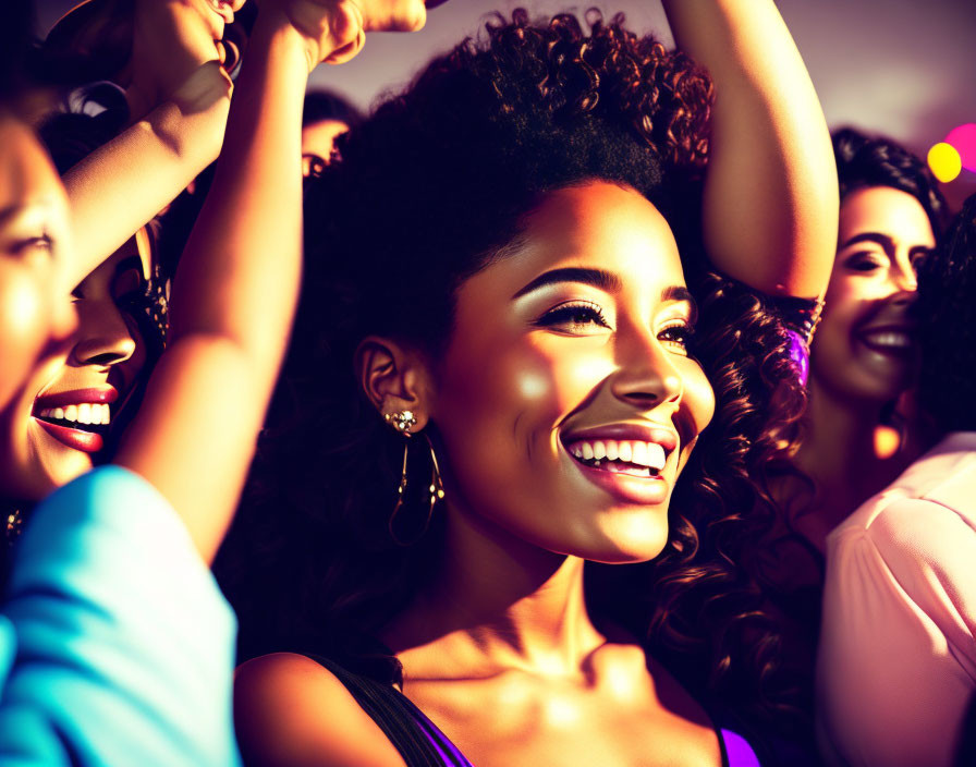 Curly-haired woman smiling at festive event with warm lighting