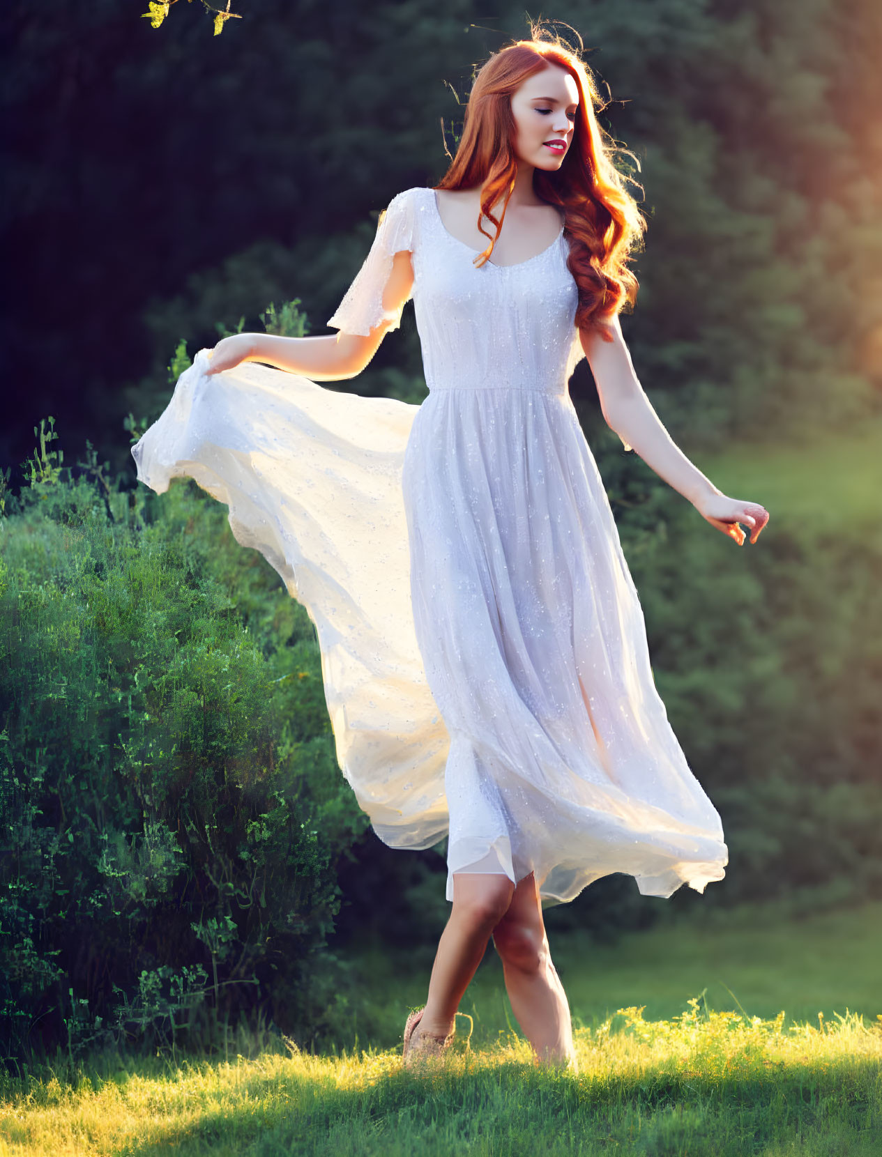 Red-haired woman twirls in sunlit meadow in flowing white dress